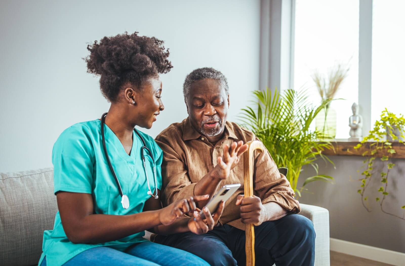 An older man speaking with a caretaker in assisted living.
