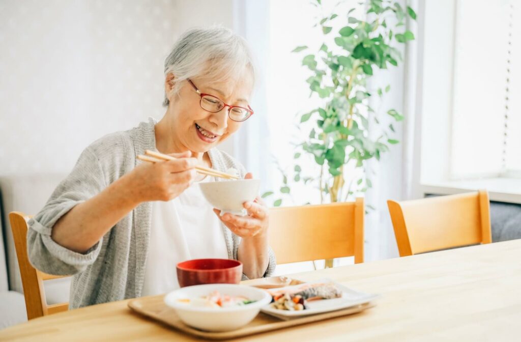 A senior with dementia happily eats a bowl of rice, managing appetite with smaller, more frequent meals