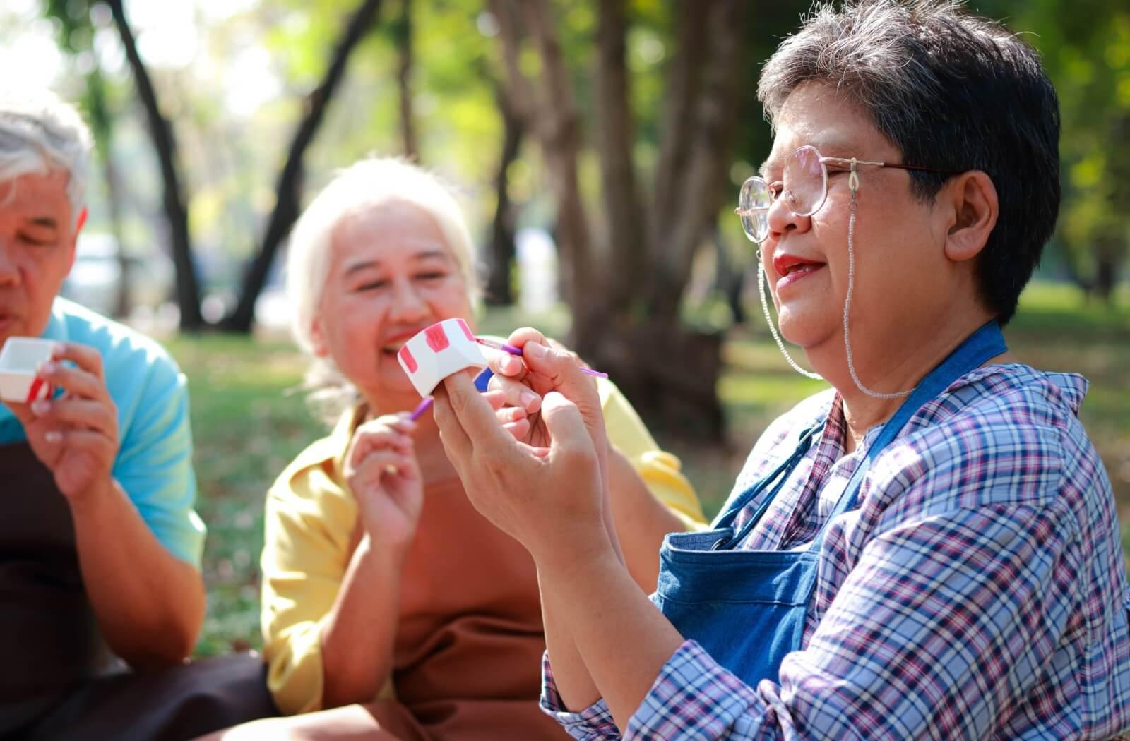 A group of seniors with limited mobility enjoys working with crafts to maintain fine motor skills.